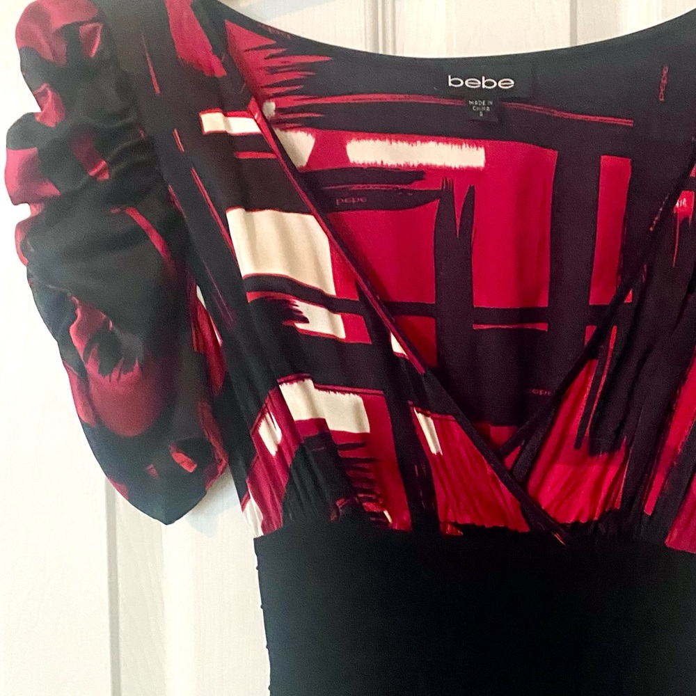 Sexy, classy, BeBe bodycon dress with ruffle cap sleeves & ruffle bottom.